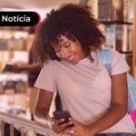 Menina olhando para celular com expressão feliz.