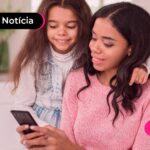 Mulher ao lado de criança olhando celular.