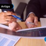 Pessoa conferindo documentos para declarar ações no Imposto de Renda.