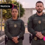 Homem e mulher fardados com uniforme da polícia penal.