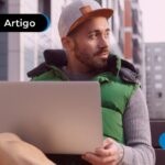 Homem com notebook lendo sobre empregos fora do Brasil.