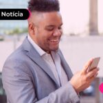 Home sorrindo enquanto lê notícia sobre novo crédito do FGTS que será depositado.