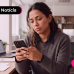 Mulher olhando triste para celular.