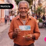 Homem idoso em rua segurando notas de dinheiro.