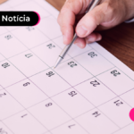 Pessoa olhando calendário do mês de junho para descobrir quando o quinto dia útil deve cair.