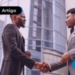 Homens de terno conversando formalmente sobre assuntos que remetem a adquirente e subadquirente.