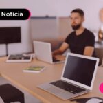 Homem trabalhando em um escritório moderno com notebooks para algo remetente ao atendimento do INSS.