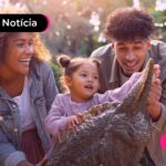 Família brincando com criança em parque.