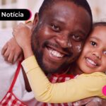 Criança abraçada com pai em casa,