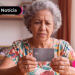 Idosa com cartão de crédito na mão.