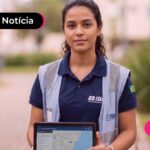Mulher de uniforme do IBGE segurando tablet.