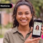 Mulher segurando celular com carteira de identidade.
