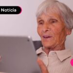 Pessoa de idade usando dispositivo móvel para ler notícia sobre portaria do INSS sobre biometria para benefícios.