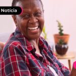 Pessoa de idade sorrindo ao ler notícia sobre valores atrasados do INSS.
