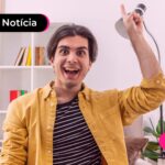 Homem de camisa amarela celebrando uma conquista alegremente.