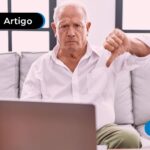 Idoso mexendo no celular com expressão de desaprovação.