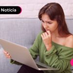 Mulher olhando chateada para computador.