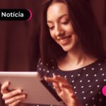 Jovem lendo notícia sobre consulta do segundo lote da restituição do IR 2026.