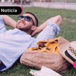 Pessoa deitada em grama de parque.