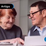 Casal de idosos sentados olhando papéis.