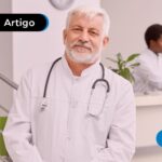 Médico de jaleco branco posando para a foto.