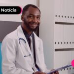 Homem de jaleco branco sentado olhando para a foto.