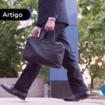 Homem com traje formal segurando uma maleta preta.