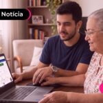 Homem ajudando uma idosa a consultar informações importantes.