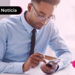 Homem olhando para celular em trabalho.