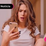 Mulher segurando celular expressando dúvidas.