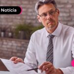 Homem com traje social segurando um documento importante.