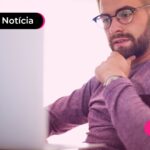 Homem de óculos lendo restituição do IR.