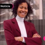 Mulher de cabelos cacheados posando pra foto.