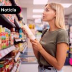 Mulher no supermercado olhando o valor dos produtos.