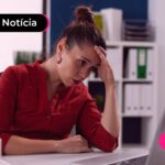 Trabalhadora com expressão preocupada com empresa atrasando pagamento do FGTS.