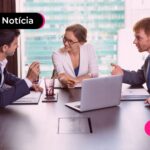 Pessoas com trajes sociais sentados em uma mesa.