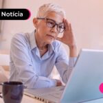 Idosa lendo sobre golpes que usam o nome do INSS.