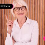 Idosa com trajes sociais olhando para a foto.