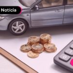 Calculadora, moedas e miniatura de carro.