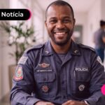 Homem com uniforme da polícia sorrindo para a foto.