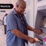 Senhor tirando dinheiro em caixa.