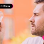 Homem jovem segurando lâmpada para remeter à energia elétrica.