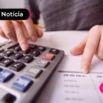 Pessoa usando calculadora para entender custo de empréstimo.