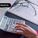 Calculadora e pasta em cima de uma mesa.