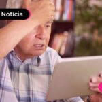 Idoso vendo novo aviso do INSS sobre golpe.