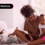 Mãe em cima da cama com seus filhos.