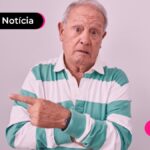 Idoso com o dedo apontando pro lado.