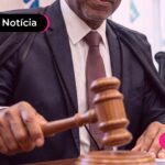 Homem de terno segurando um martelo de juíz.