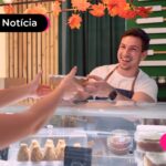 Atendente de cafeteria recebendo um cliente no balcão.