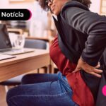 Pessoa com dor nas costas em ambiente de trabalho.